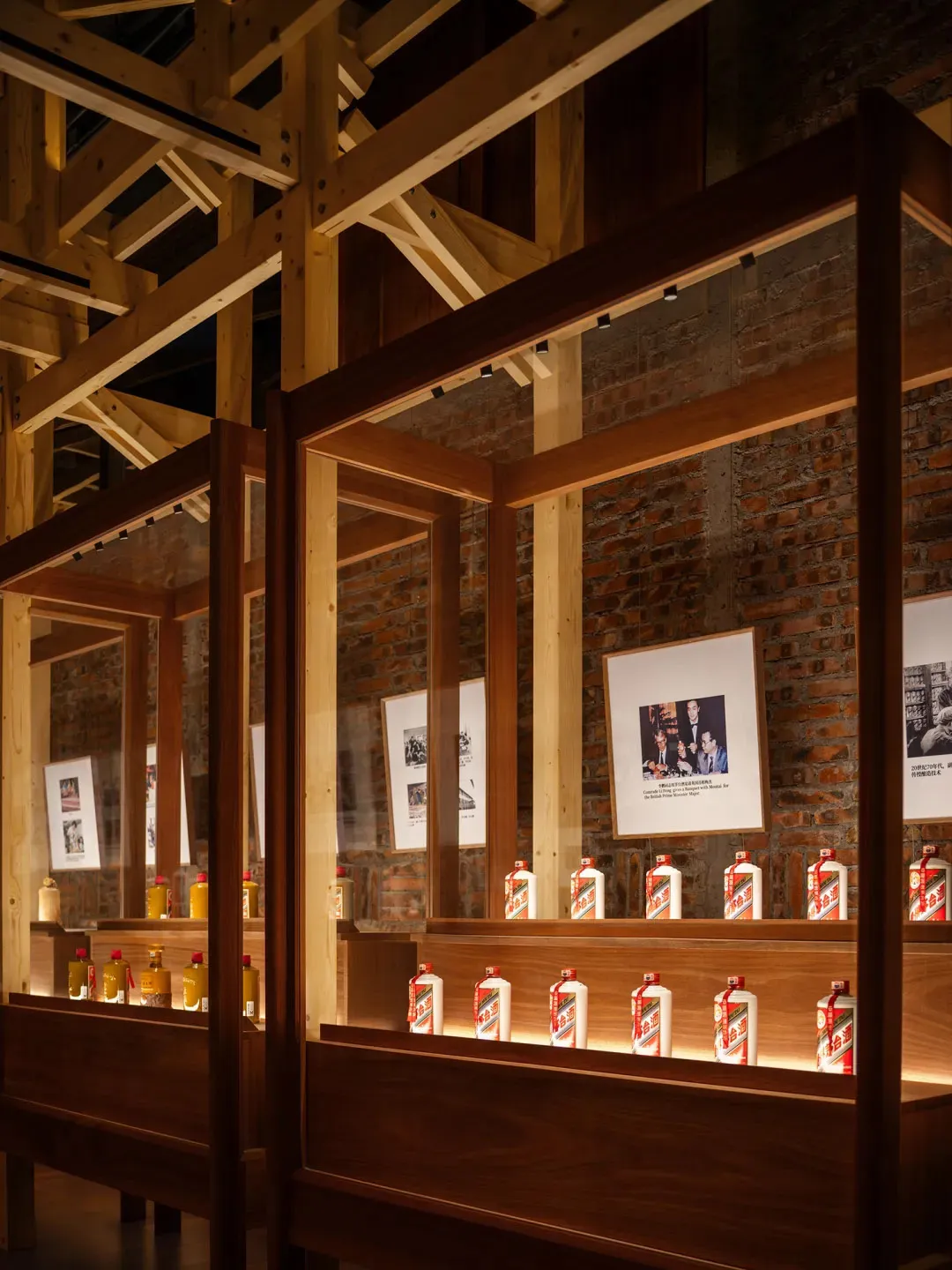 Photograph of a brick building with a wooden display case featuring a collection of bottles, set against a brick exterior