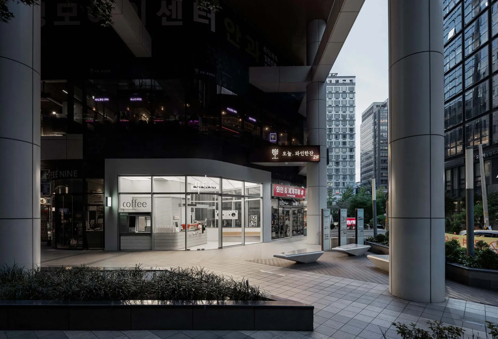 A modern coffee shop with a large window and a bench outside, providing a welcoming atmosphere for customers