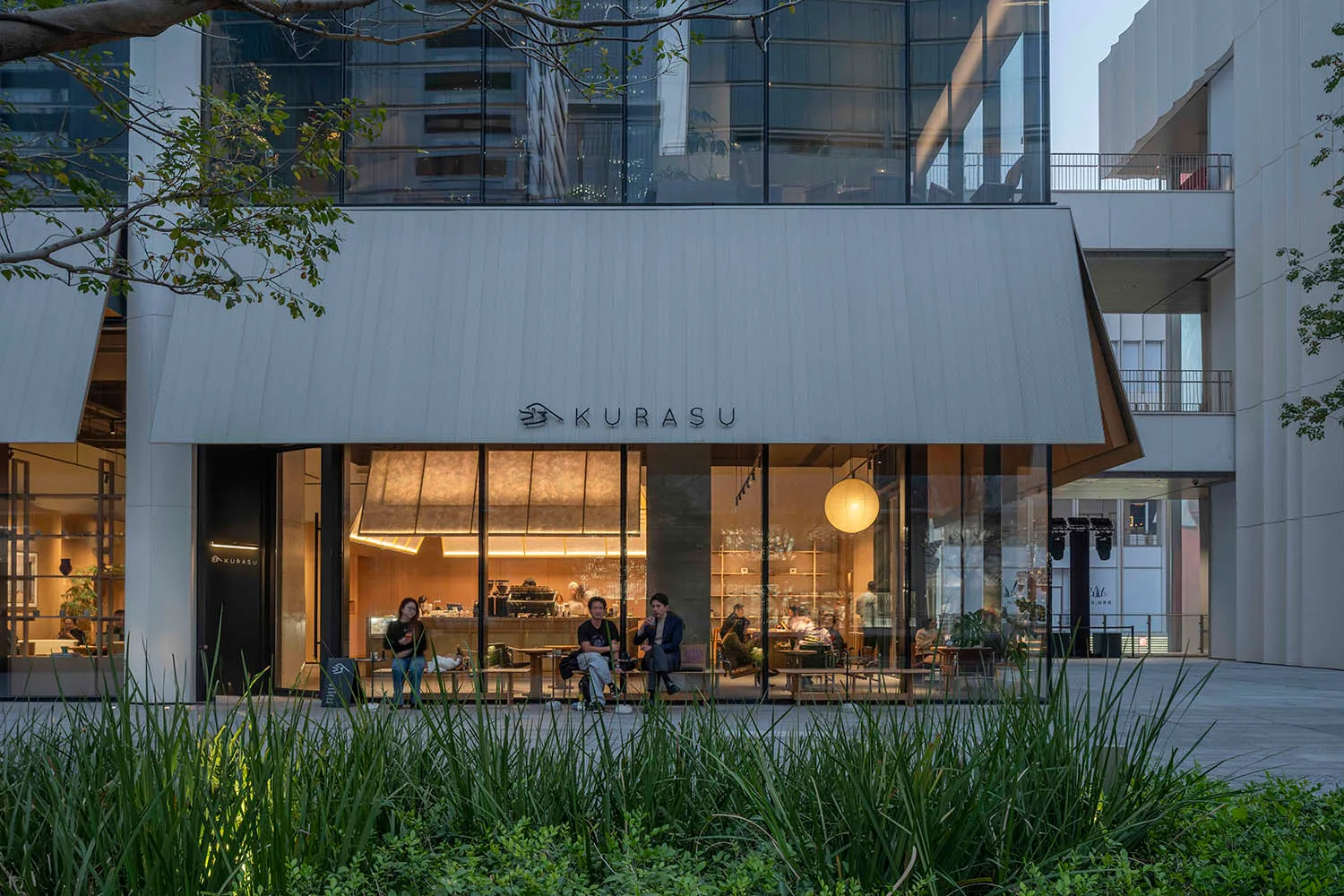 Well-lit restaurant interior with modern furniture, large glass front, and natural light