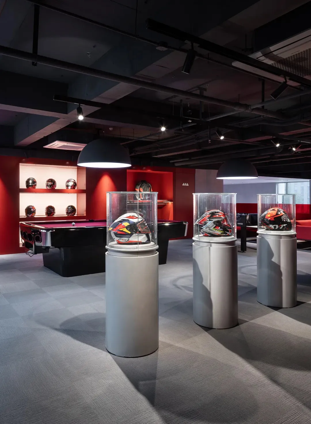 Casual game room with a red accent wall, a black pool table, and sports equipment on display