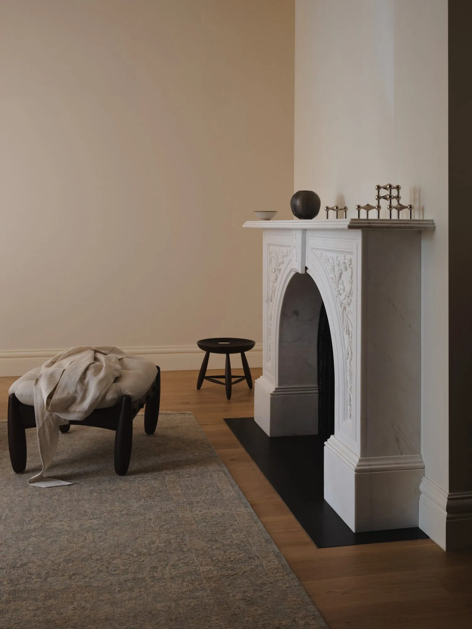 Comfortable living space with a white fireplace, a chair, a couch, and a bowl on a surface, well-lit and inviting