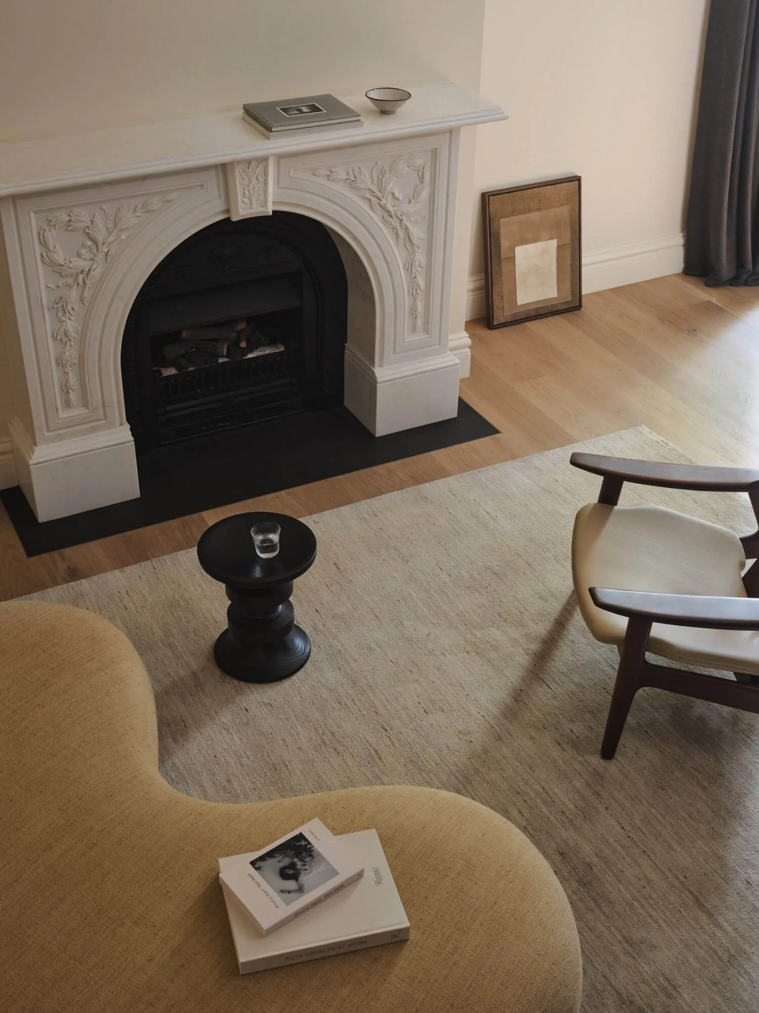 Cozy living room with a white fireplace, a chair, and inviting atmosphere