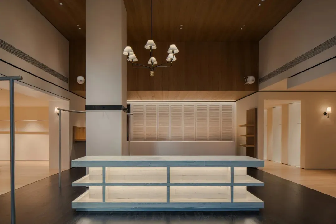 A clean and organized public space with a wooden floor, a white counter, and natural light from the windows