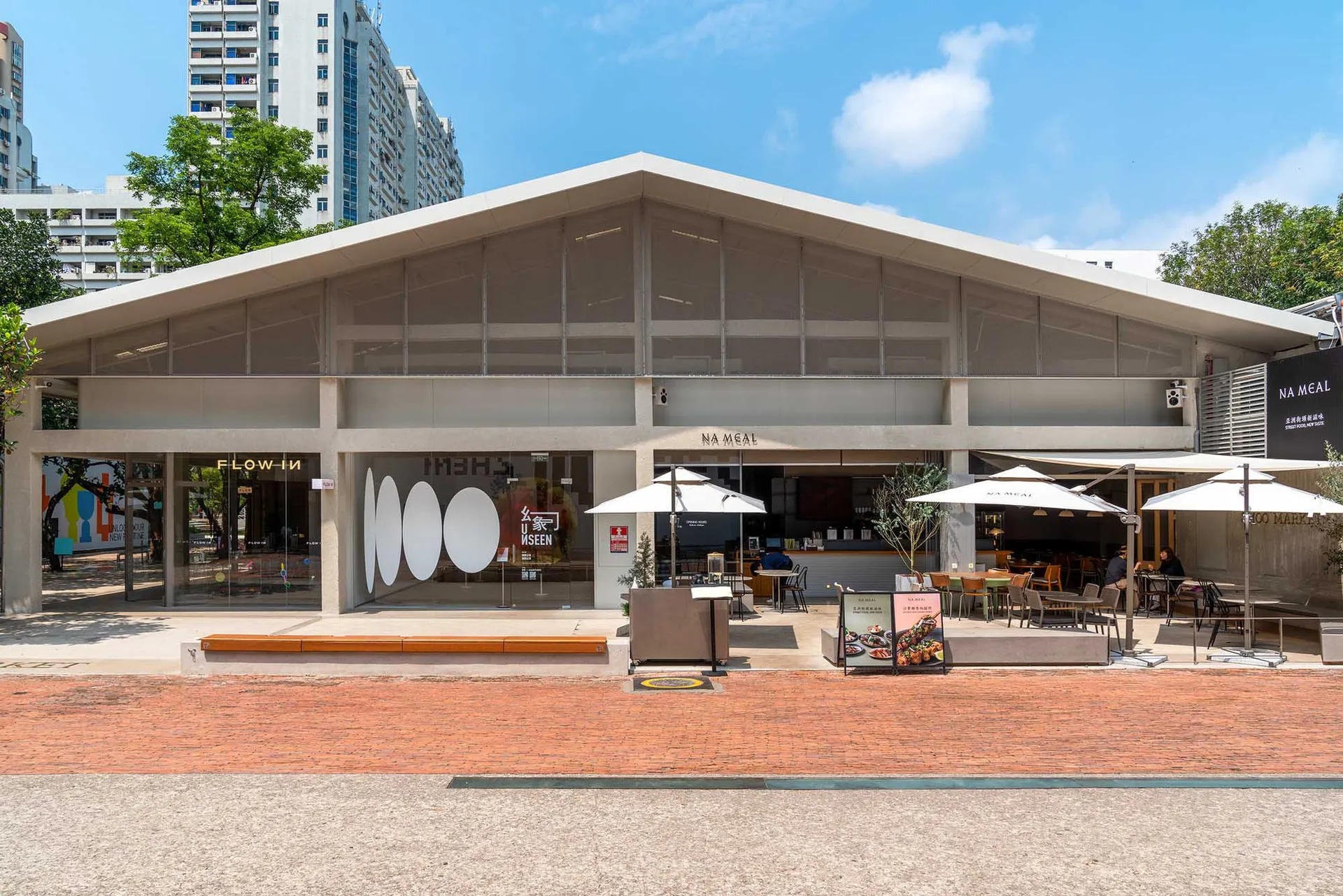 A modern restaurant with a large glass front, well-lit interior, and comfortable seating areas with dining tables and chairs