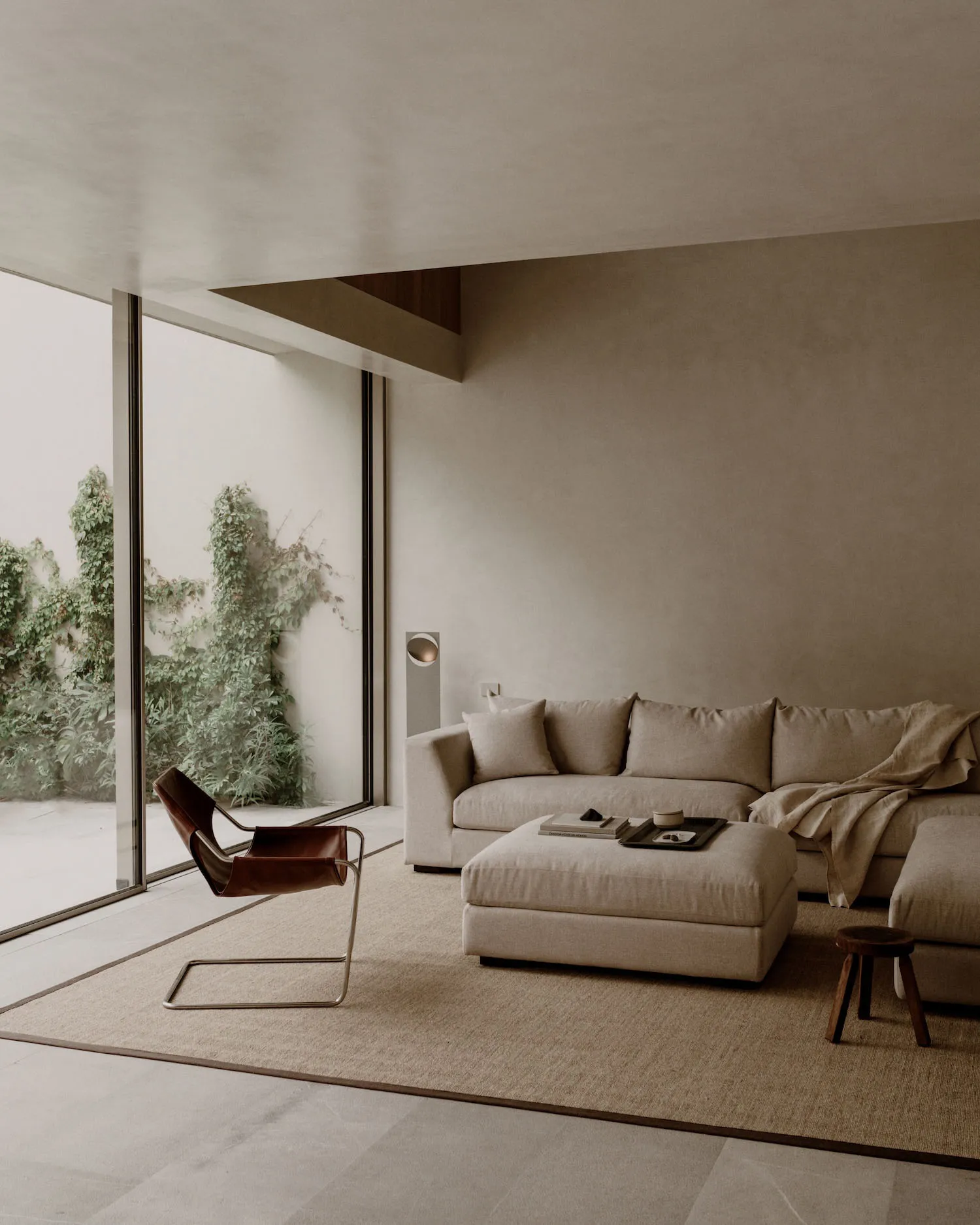 A well-lit living room with a couch, chair, and rug, featuring various decorative items and a cozy atmosphere
