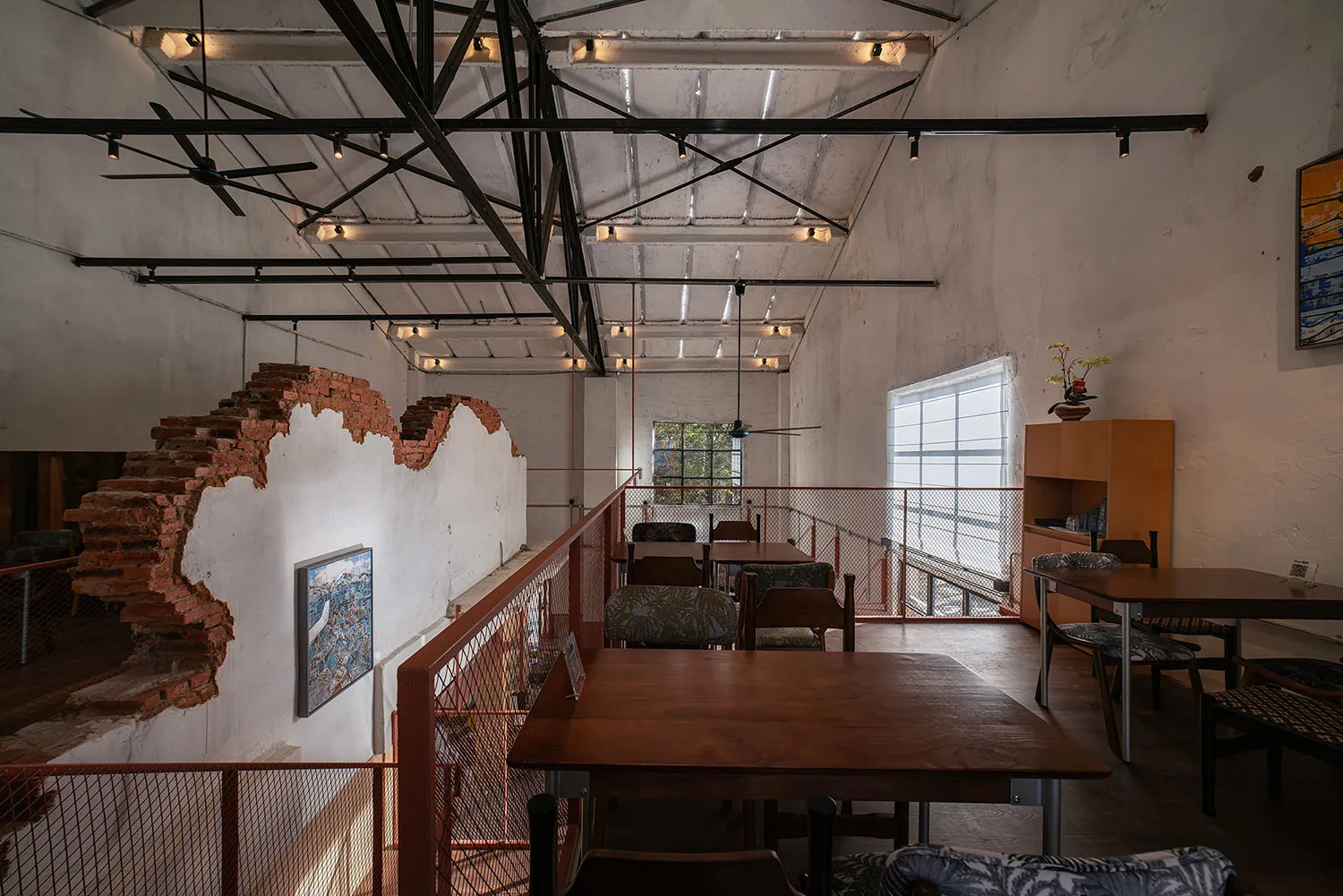 光線充足的餐廳餐區，配有木質地板、木桌與椅子，自然光線從窗戶灑入