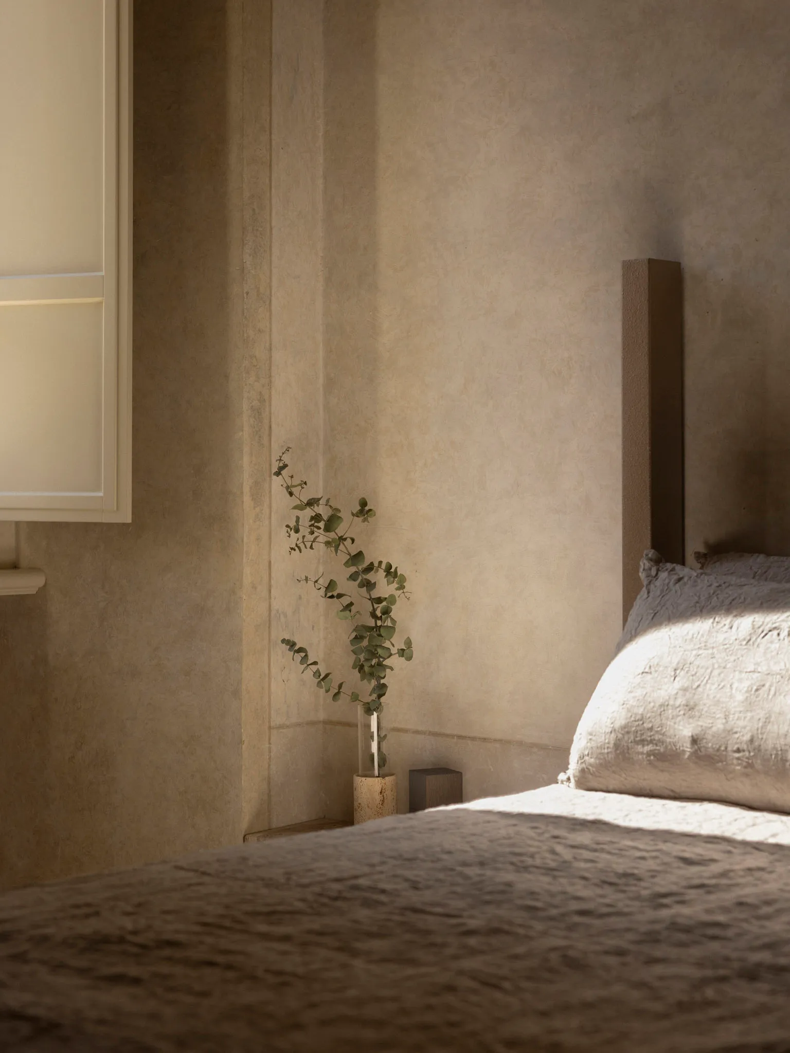 A modern bedroom with a bed, potted plant, and open window, featuring wood and fabric materials in a predominantly neutral color palette