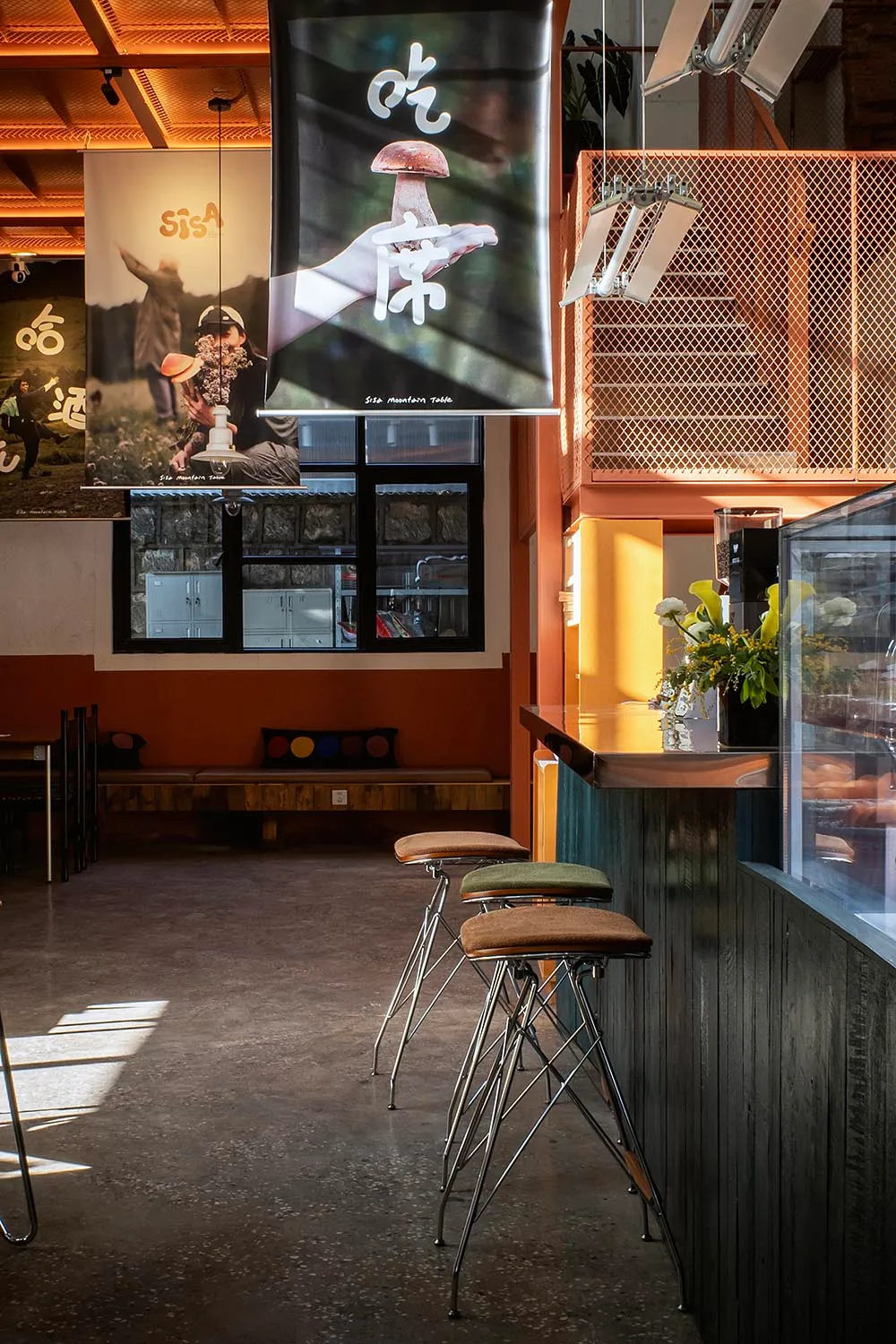 A cozy restaurant bar with a wooden counter and chairs, set in an Asian-inspired interior with inviting atmosphere