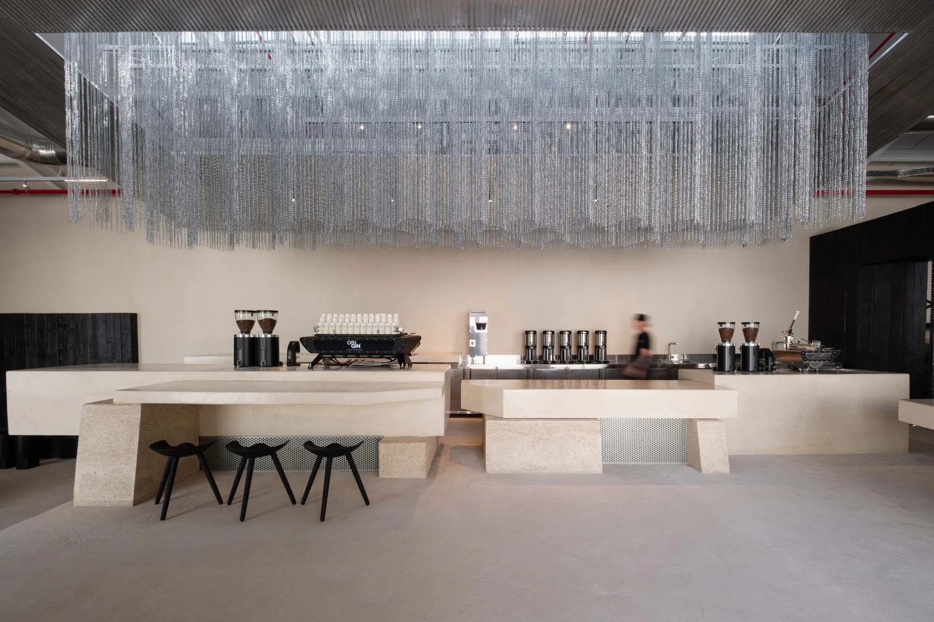 A modern restaurant with a marble counter, kitchen area, and soft lighting, creating a comfortable atmosphere for customers