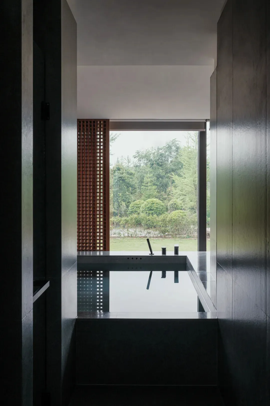 A modern bathroom with a large window, sink, bathtub, and toilet, featuring a bright and airy atmosphere