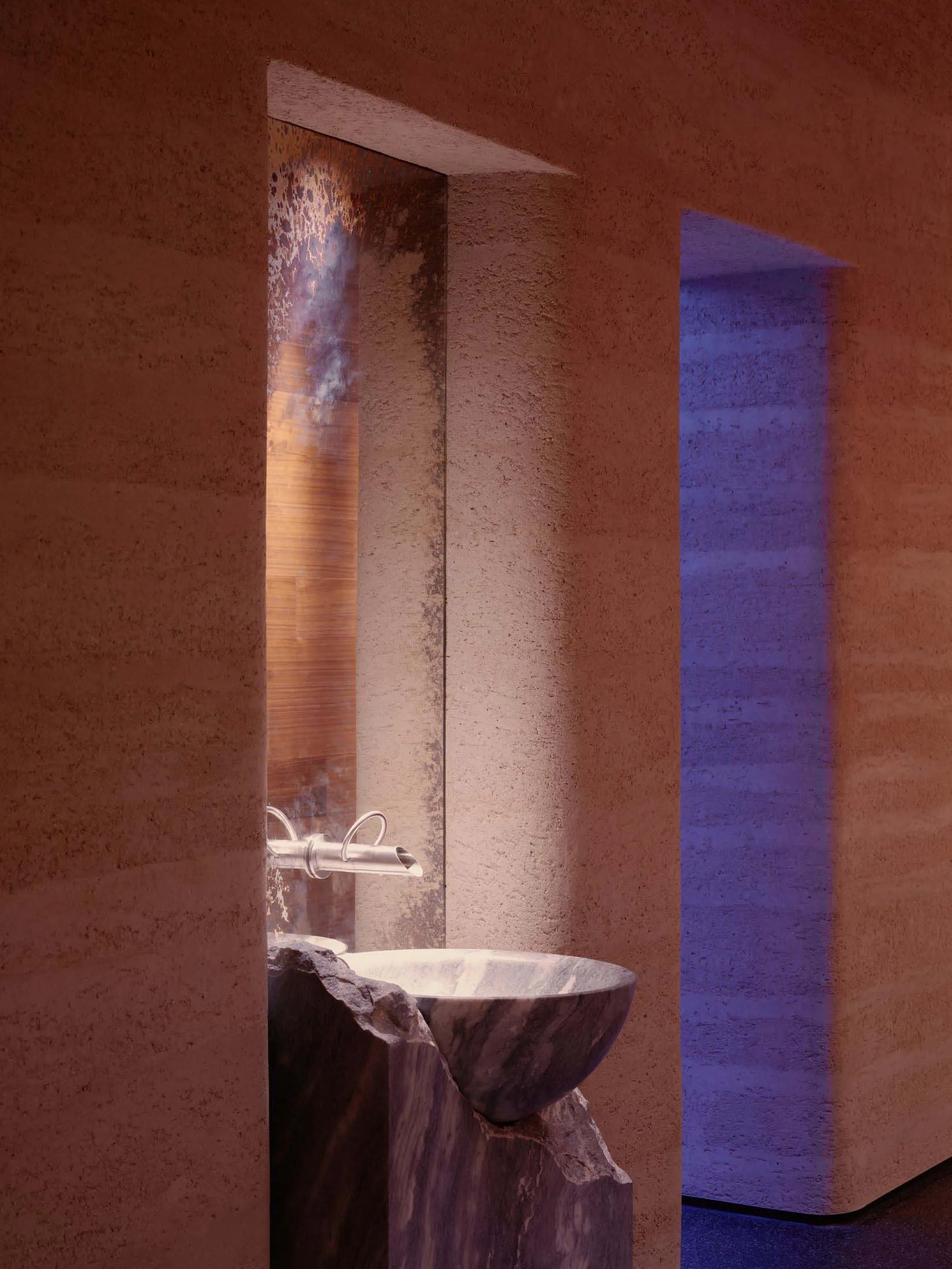 Bathroom with a sink and toilet in a dimly lit space with a stone-like appearance
