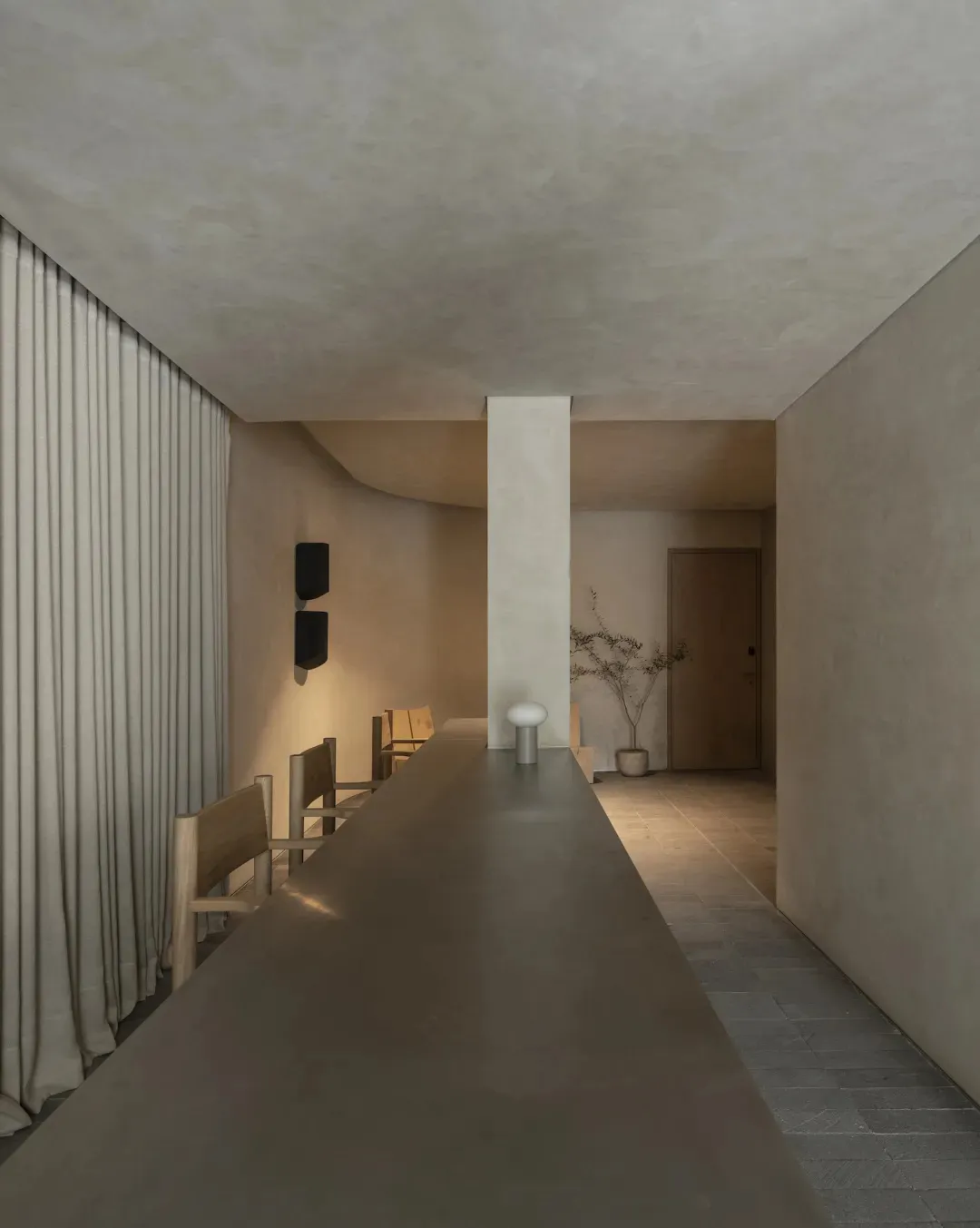 A modern kitchen with a dark counter, sink, and dining table, set in a dimly lit space with a cozy atmosphere