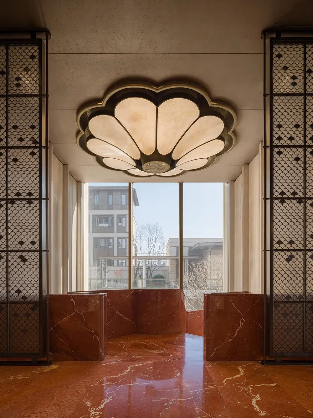 Well-lit lobby with marble flooring, a large window, and warm atmosphere