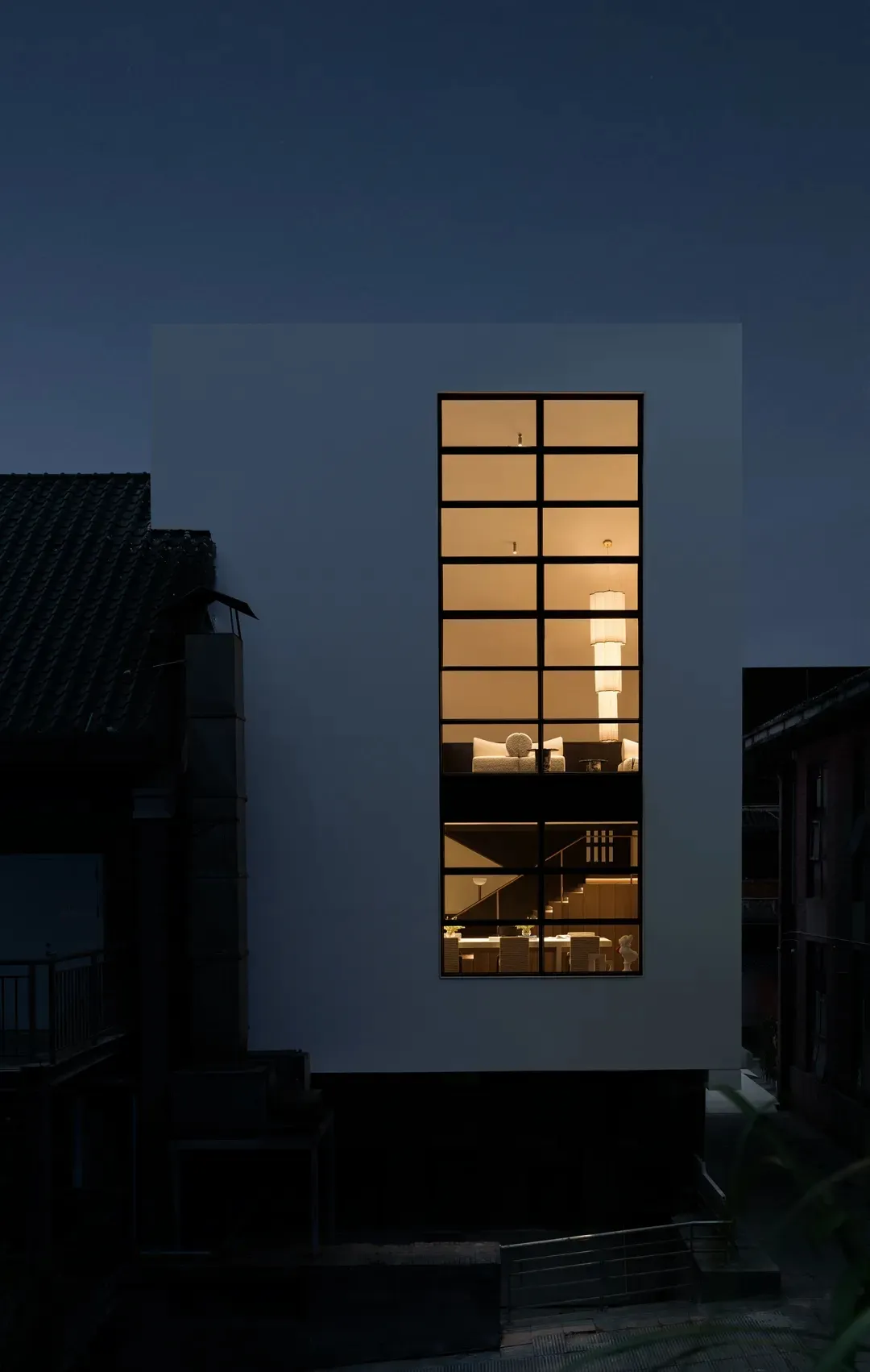 一棟大型白色住宅，採用現代設計，配有大型玻璃窗，室內明亮宜人，線條簡潔，極簡美學