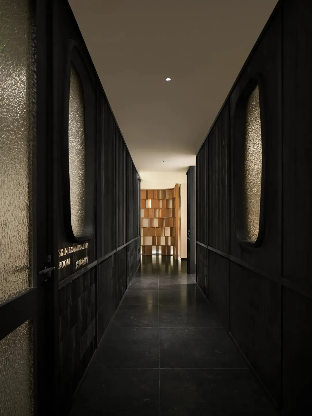 A dimly lit hallway with a black and white color scheme, lined with doors and made of wood