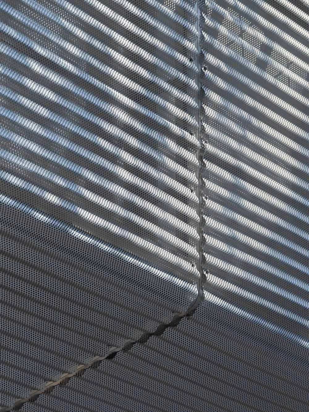 A photograph of a building with a visible crack in the metal wall near the top, suggesting potential damage or structural issues