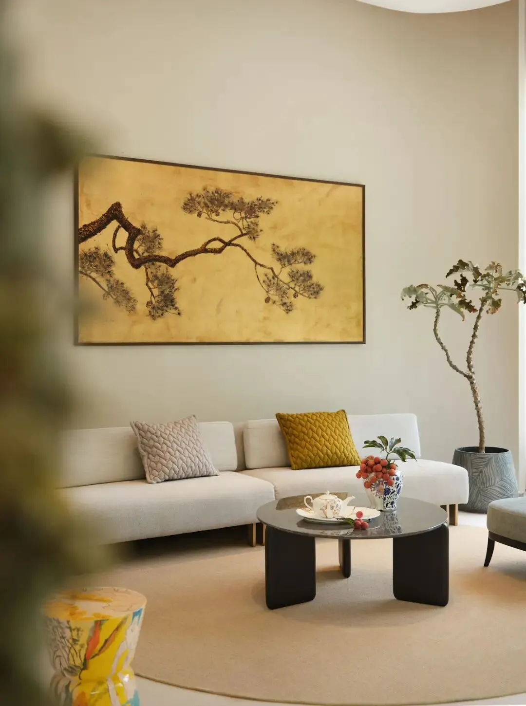 明亮的現代客廳,擺放白色沙發、黑色咖啡桌,牆上掛著大型東方畫作,營造明亮且溫馨的氛圍