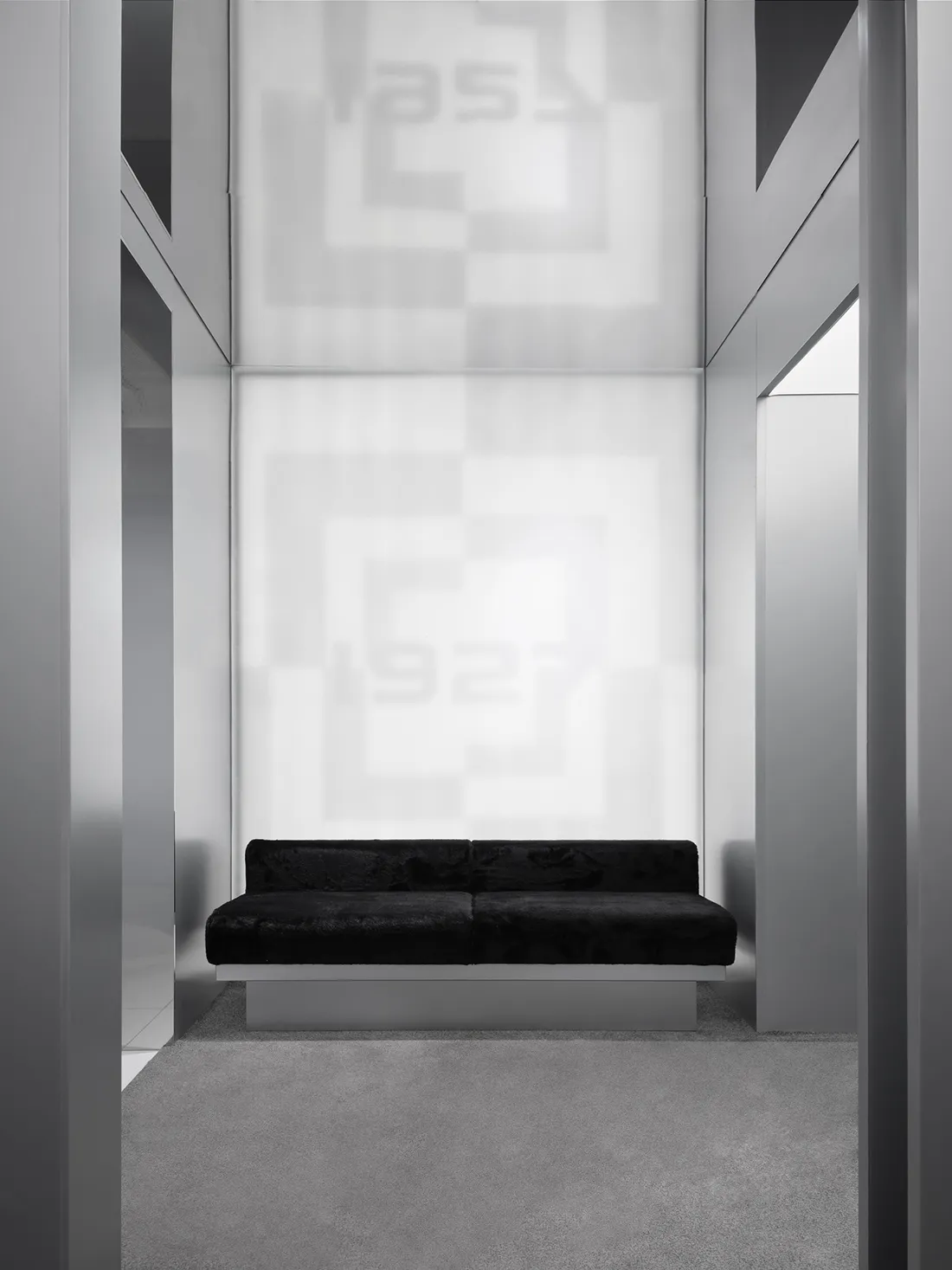 Cozy living room with a black couch against a checkered wall, dimly lit for an intimate atmosphere
