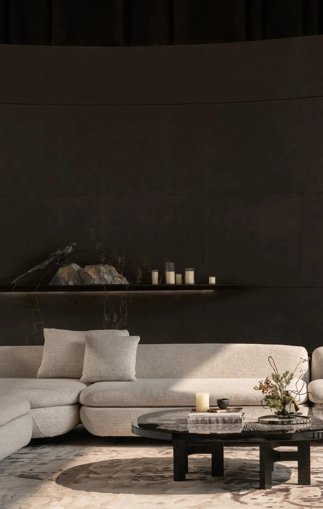 A well-lit living room with a white couch, black accent wall, and a fireplace, creating a comfortable and inviting atmosphere