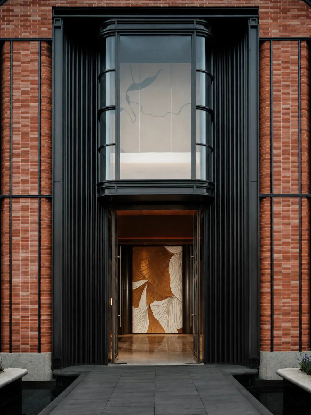 A modern building with a brick facade and a large window featuring a gold design, set against a bright and sunny day