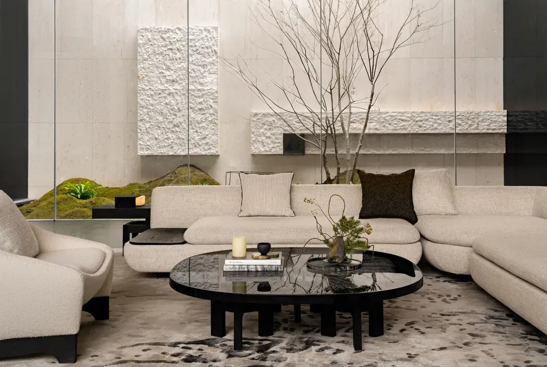 A modern living room with a black coffee table, couch, and chair, decorated with potted plants and featuring clean lines and minimalistic decor