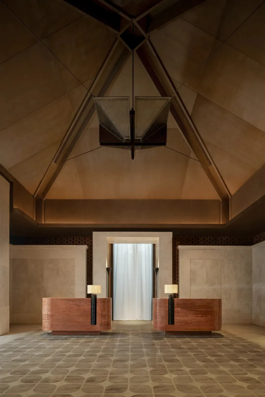 A modern lobby with wooden benches and a stone ceiling, featuring a light fixture and a clean, minimalist design