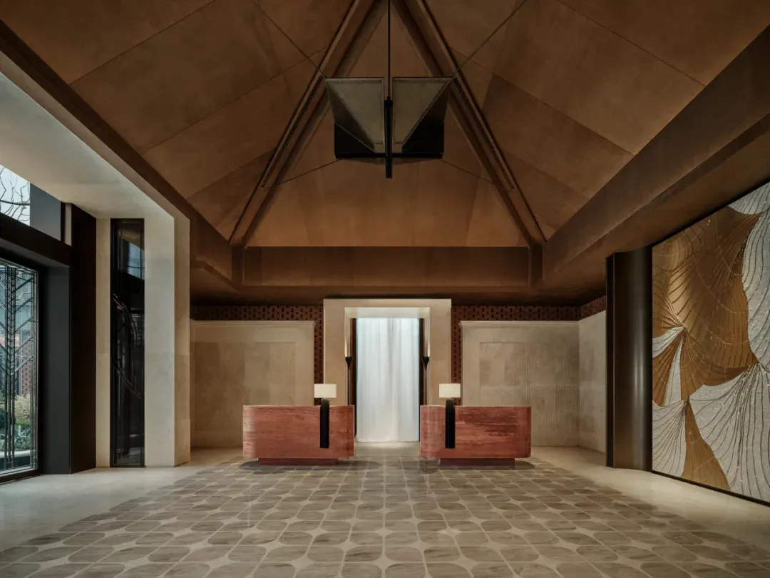A well-lit room with a wooden floor, a large wooden desk, and a couch, creating a comfortable and inviting atmosphere with warm and natural wooden elements