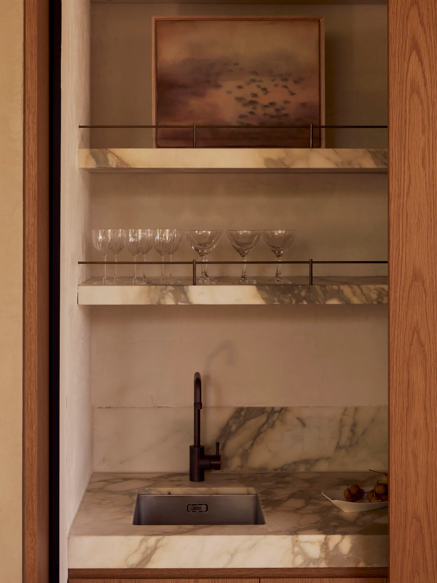 Modern kitchen with a marble countertop, metal sink, and natural light from the windows