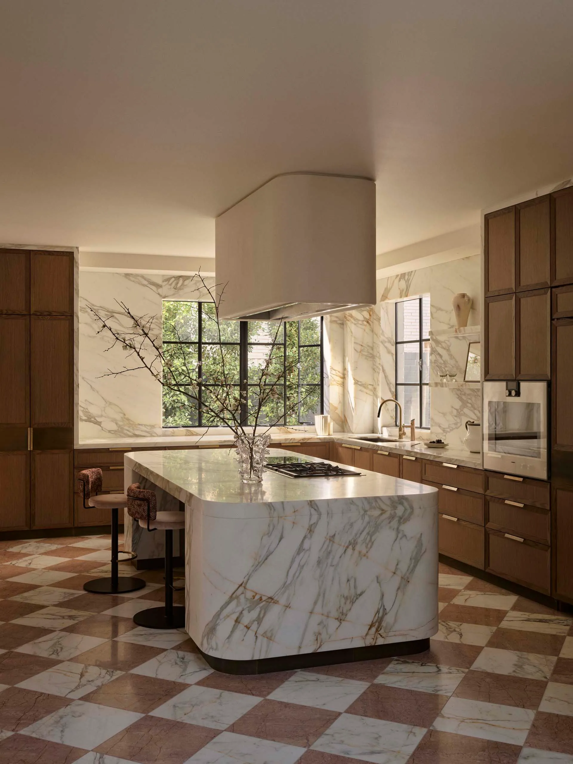 Modern kitchen with a white marble countertop, a dining table, and dim lighting