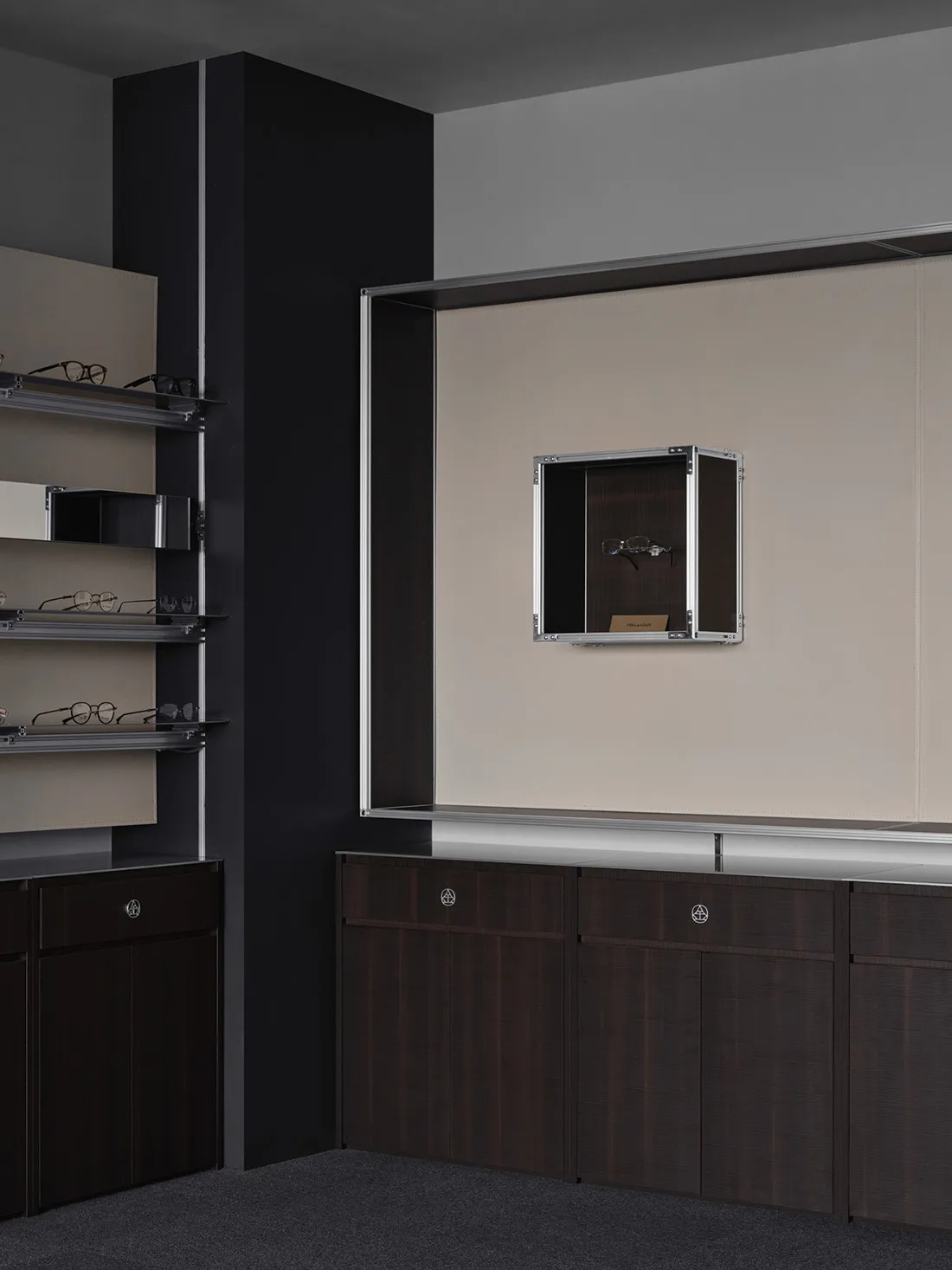 A clean and organized bathroom with a brown wooden cabinet and mirror, featuring various pairs of glasses arranged neatly on the cabinet