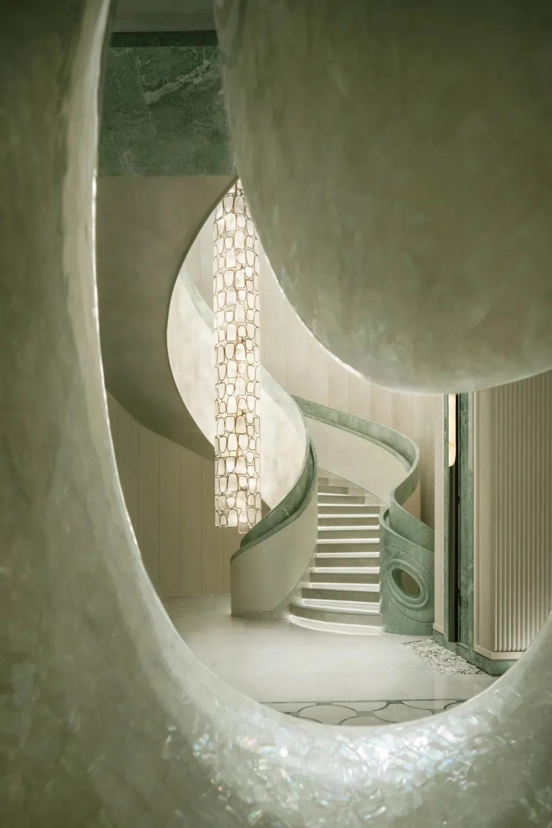 A dimly lit, curved marble staircase dominates the space, with no other objects or distractions visible