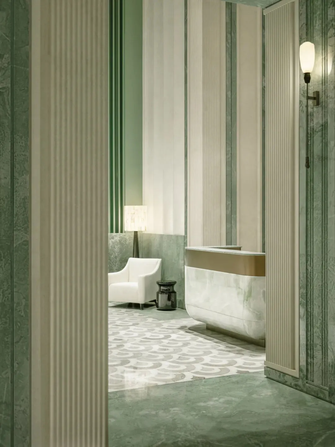 White bathroom with a green accent chair, sink, and bathtub in a dimly lit space