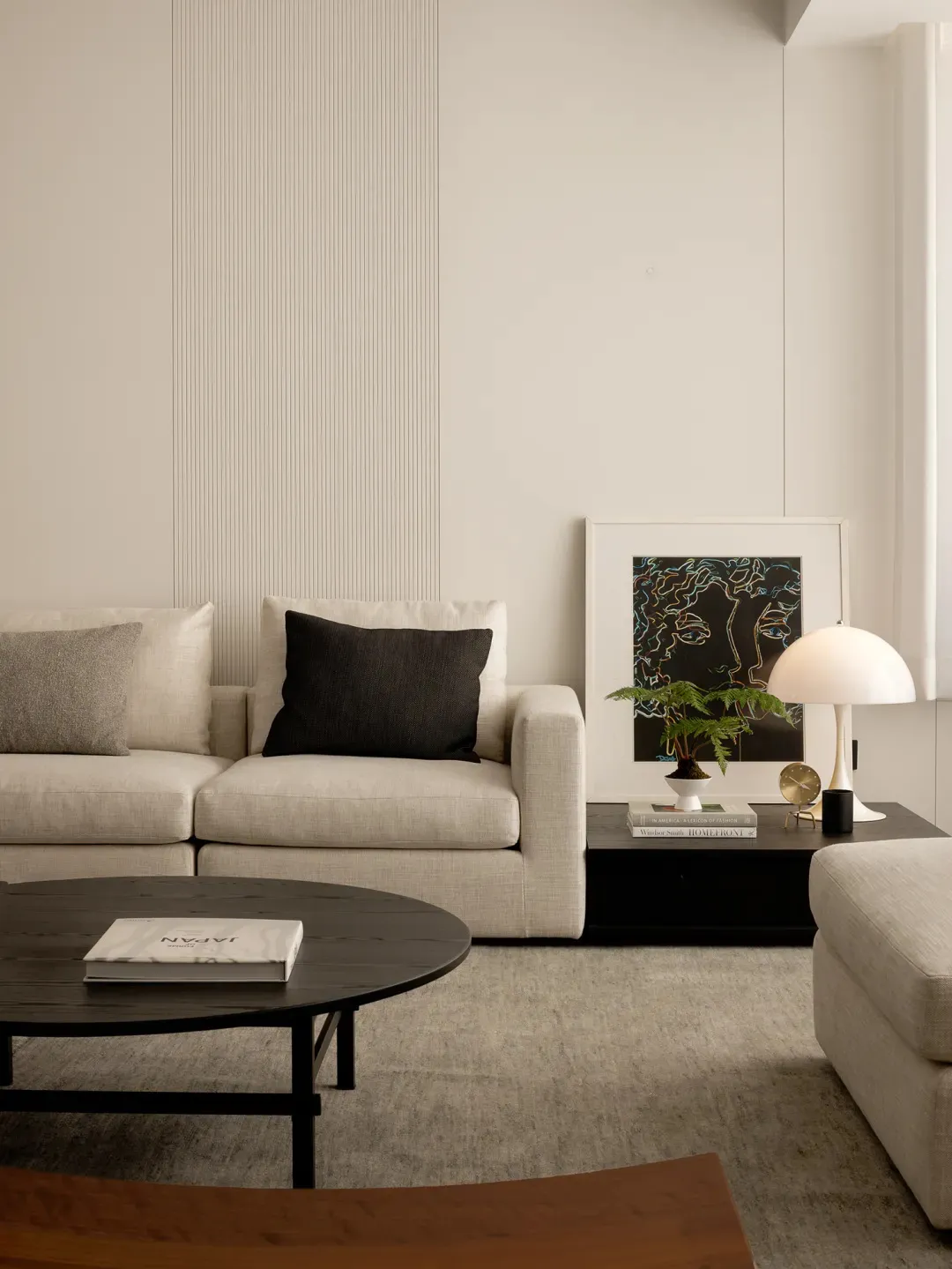 Cozy modern living space with a white color scheme, a couch, chair, coffee table, and potted plant, featuring clean lines and simplicity