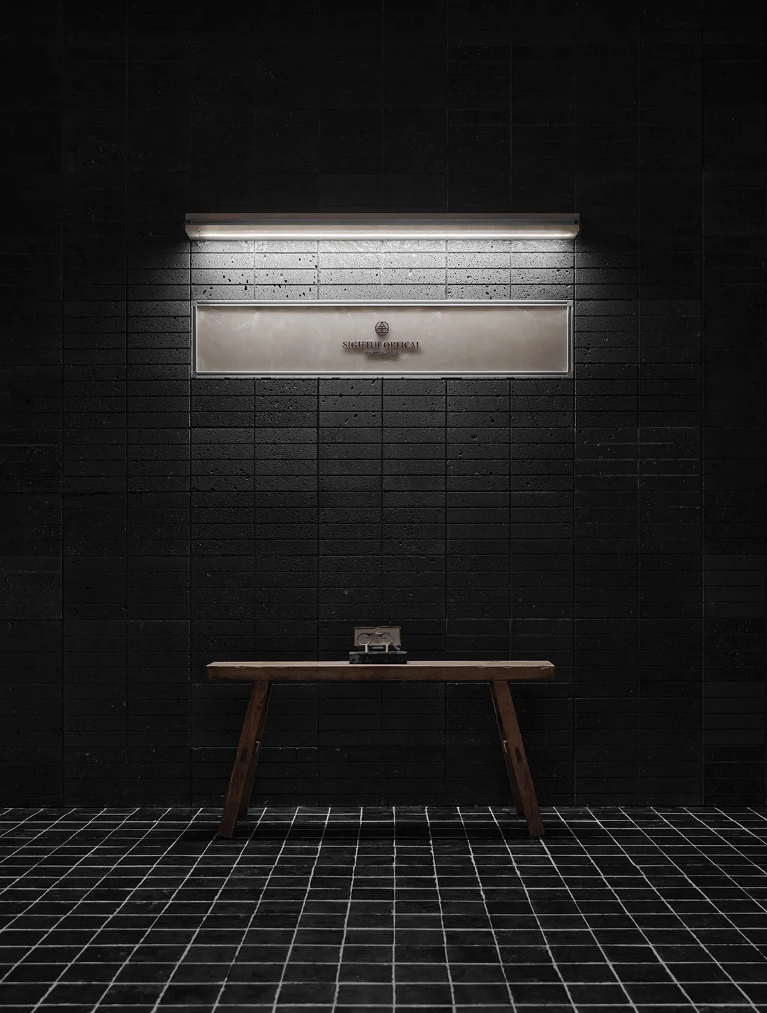 A dimly lit bathroom with a wooden bench and a mirror above it, set against a black tile floor
