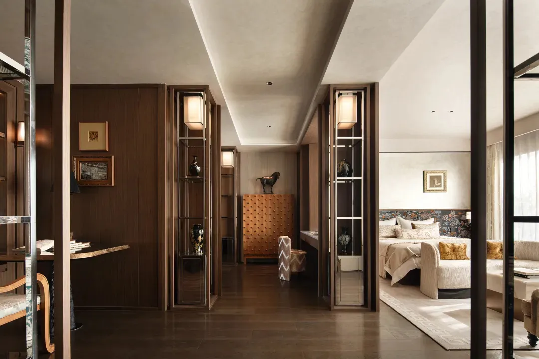 A well-lit bedroom with a wooden floor, a bed, a dresser, and a chair, creating a bright and inviting atmosphere
