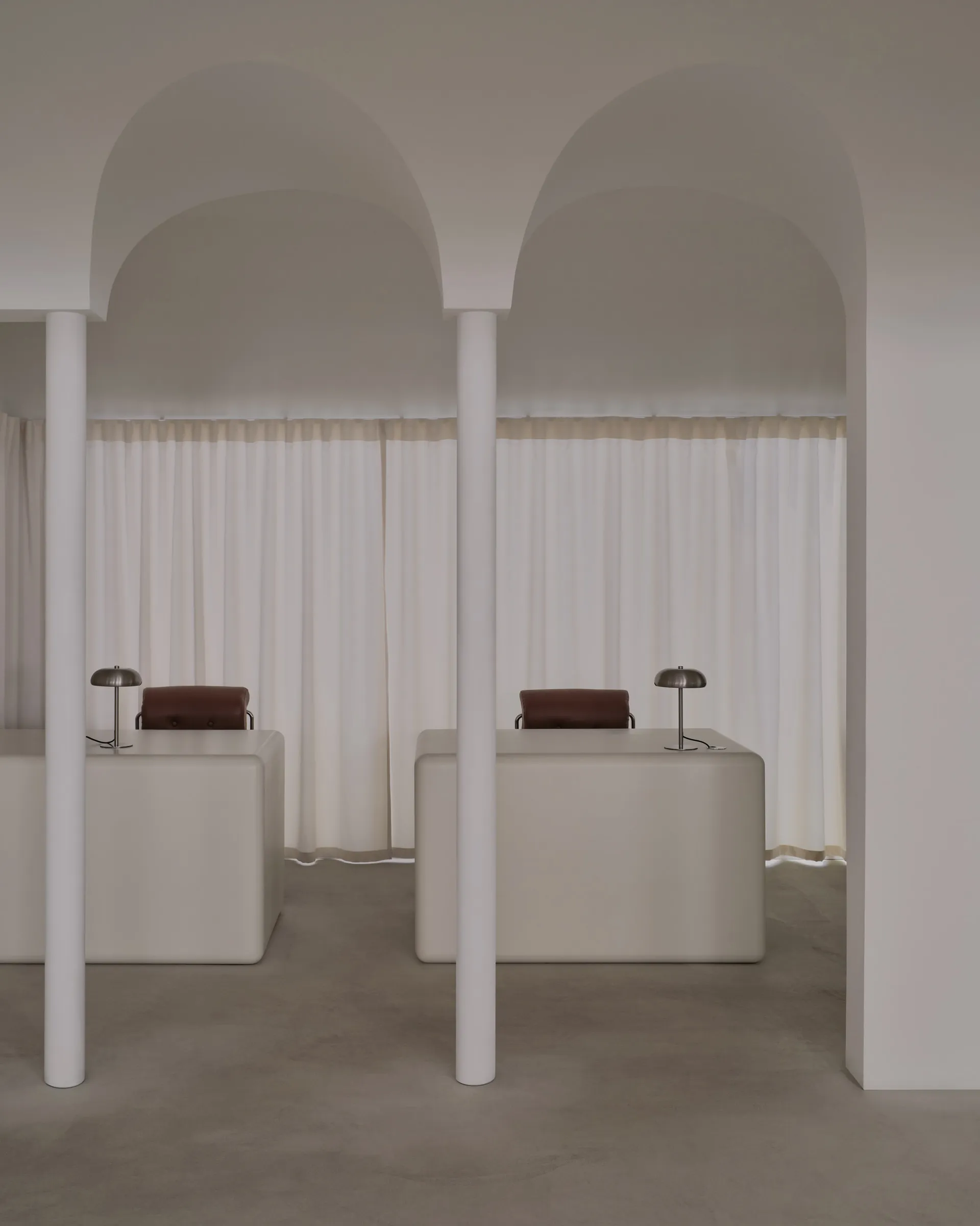 Two white desks with chairs and lamps in a clean and organized room with a focus on functionality and efficiency