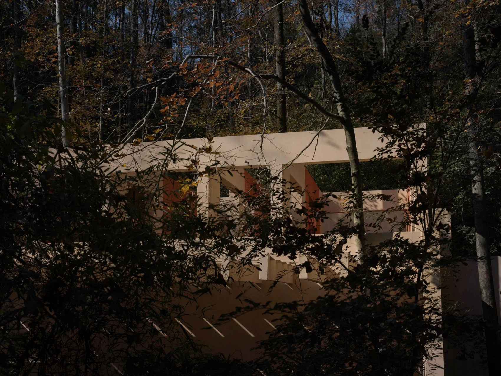 Photograph of a wooden house with a large wooden beam and patio area, featuring natural light and a warm ambiance