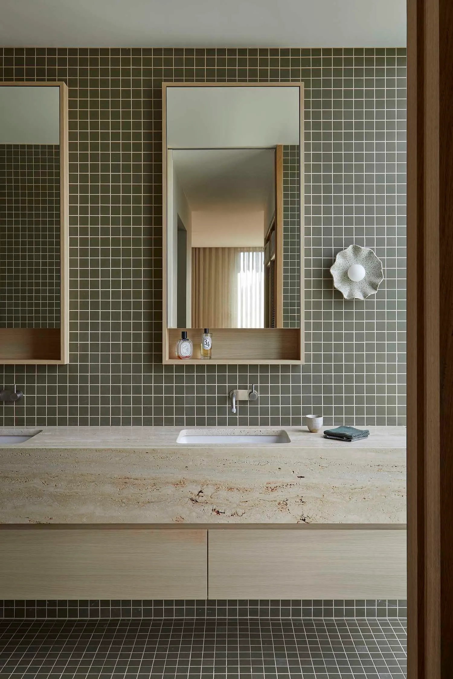 Bathroom with a sink, mirror, and tile wall in a dimly lit space