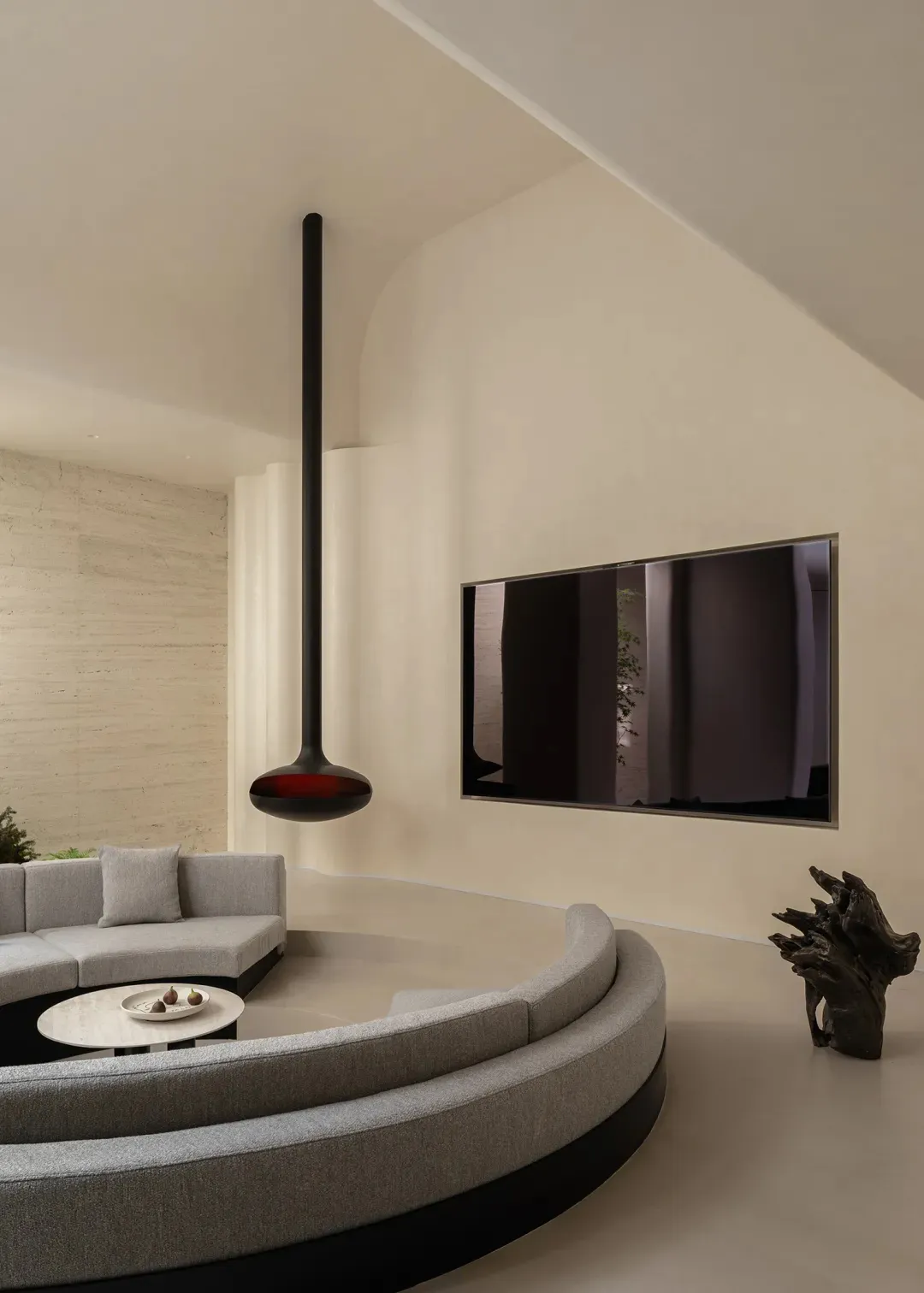 Cozy living room with a modern design, a large TV, a couch, and a chair, with natural light and dim lighting