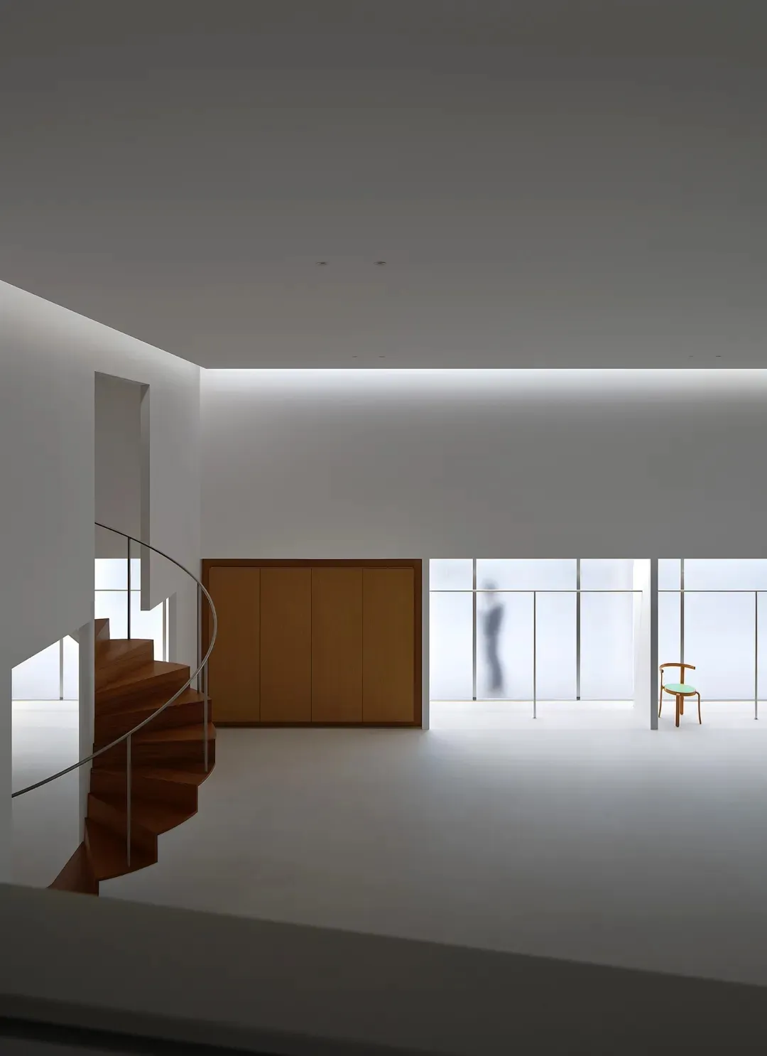 Open-plan living and dining area with a spiral staircase, white walls, and a dining table with chairs