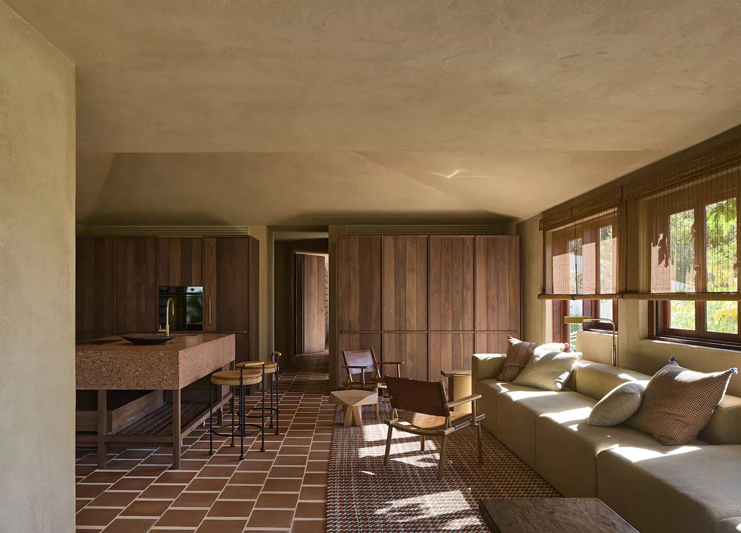 A well-lit living room with a tile floor, wooden furniture, and decorative items creating a warm and inviting atmosphere