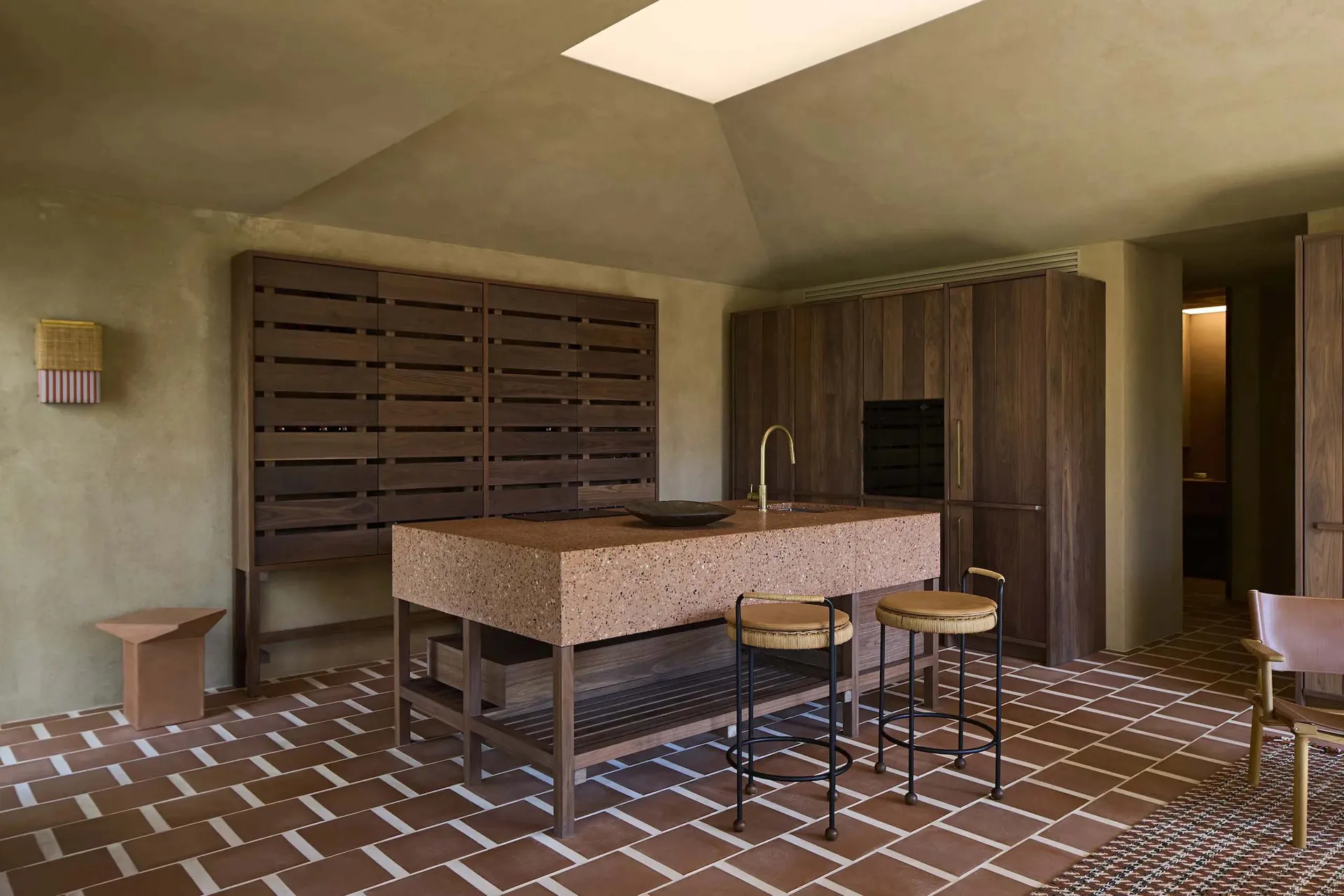 A modern kitchen with a wooden counter, tile floor, and white refrigerator, lit by natural sunlight through a window
