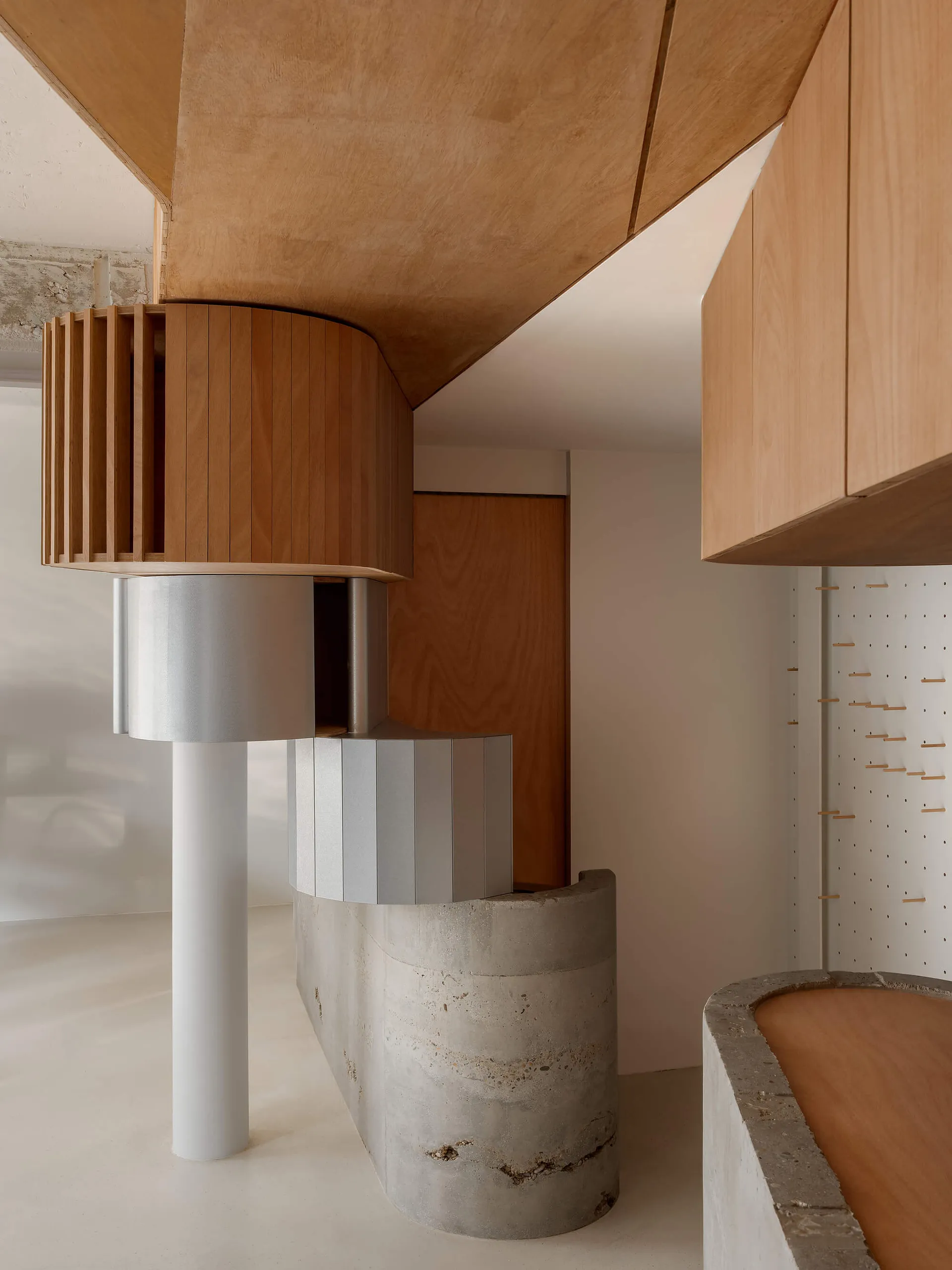 Well-lit kitchen with wooden cabinets, concrete countertops, and a modern design