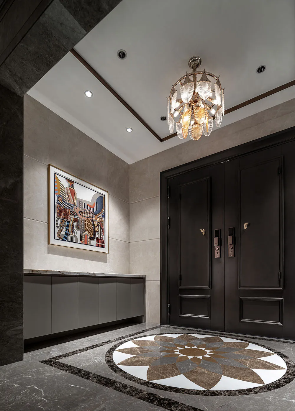 A dimly lit hallway with a chandelier, marble, and wood features, creating a cozy and intimate atmosphere