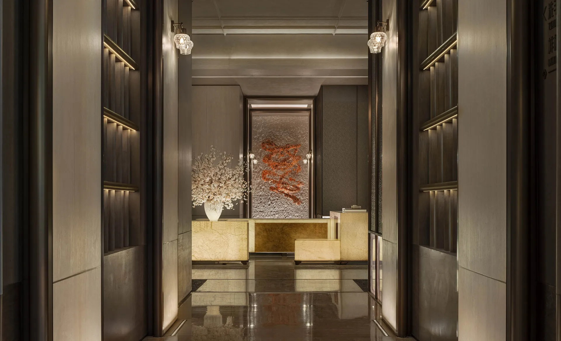A well-lit room with a marble floor, a large couch, a dining table, and a vase with flowers, giving a luxurious and sophisticated atmosphere