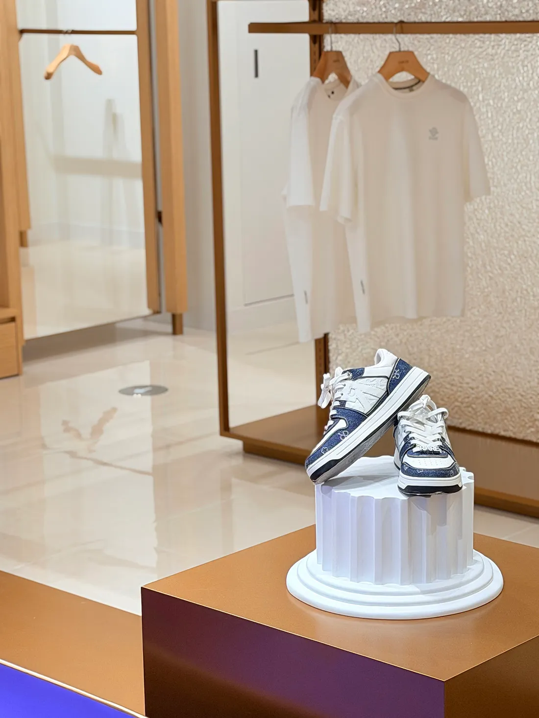 A well-lit shoe store with a display of shoes on a pedestal, arranged in a visually appealing manner