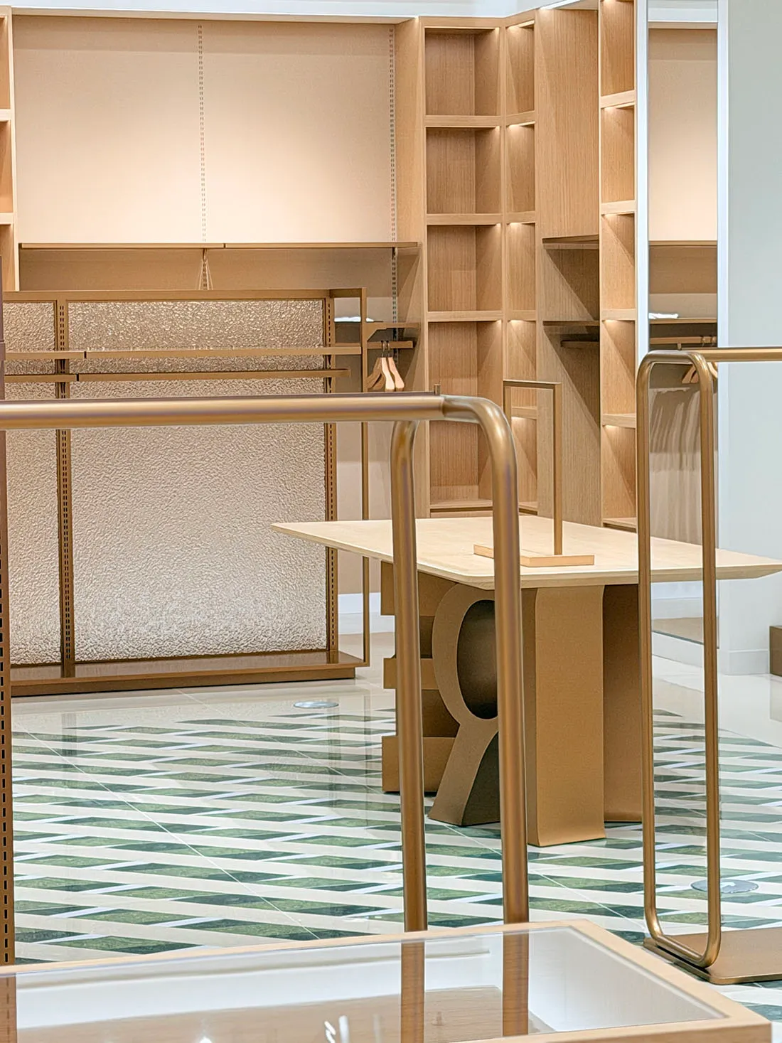 A wooden table and chair on a tile floor with a mosaic pattern, set in a retail store with soft and inviting lighting