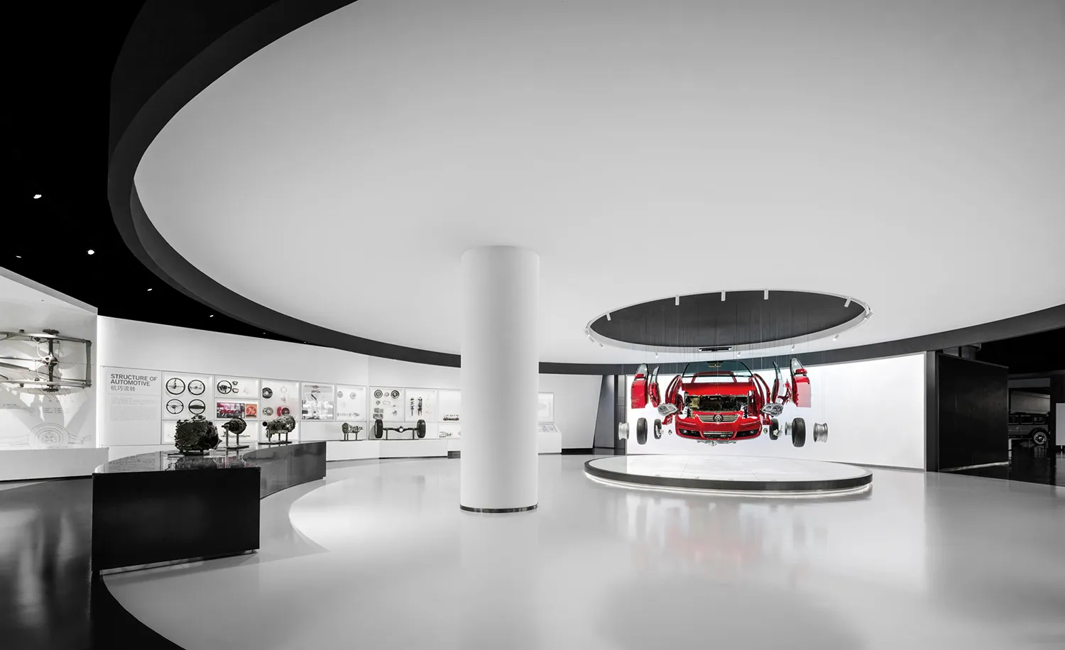 Modern white exhibition hall with dramatic curved black ceiling, glossy white floor, central white column, and a red Mercedes-Benz car displayed in exploded view on a circular platform.