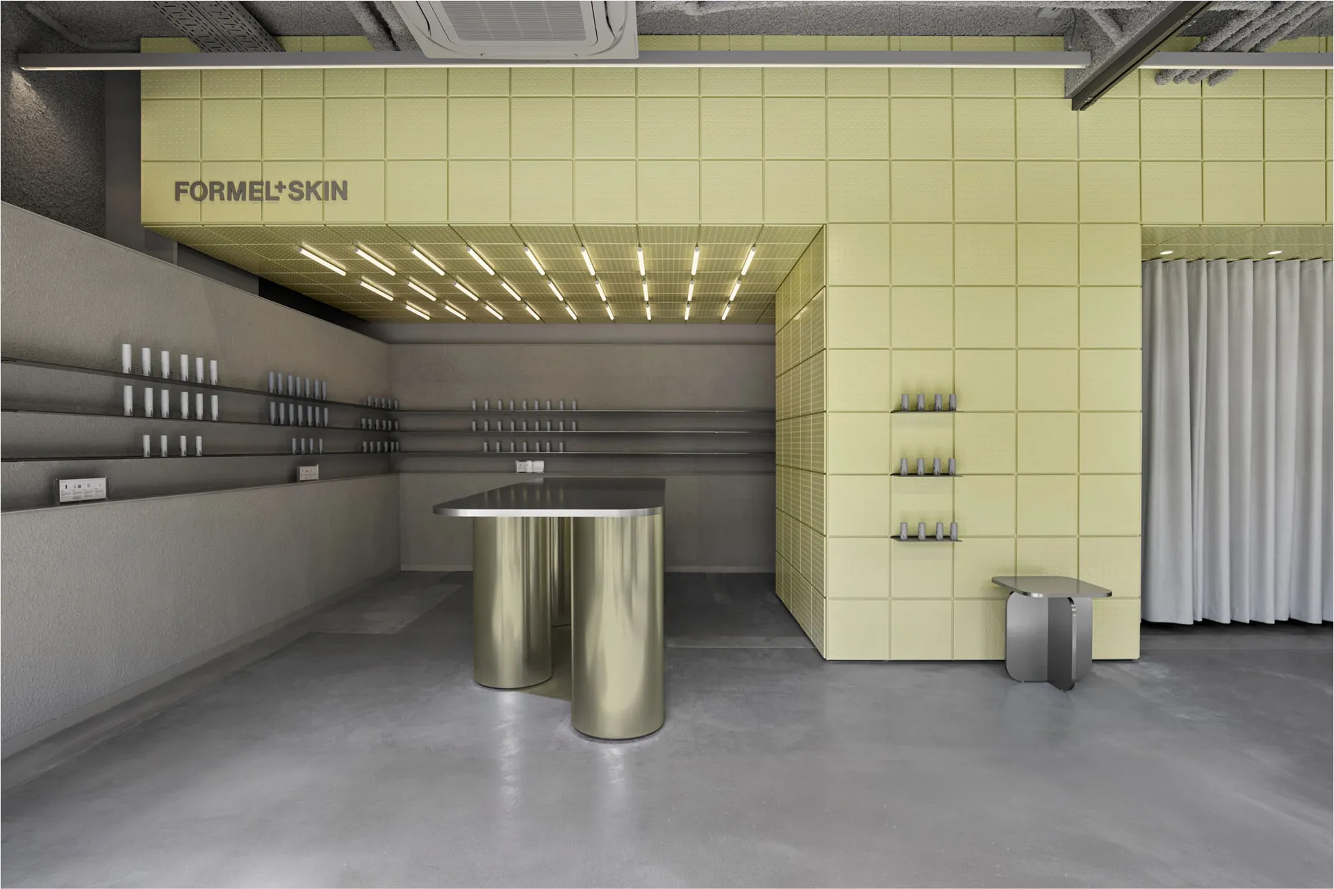 Modern beauty retail interior with lime green perforated metal ceiling and walls, stainless steel cylindrical display counter, and concrete floor.