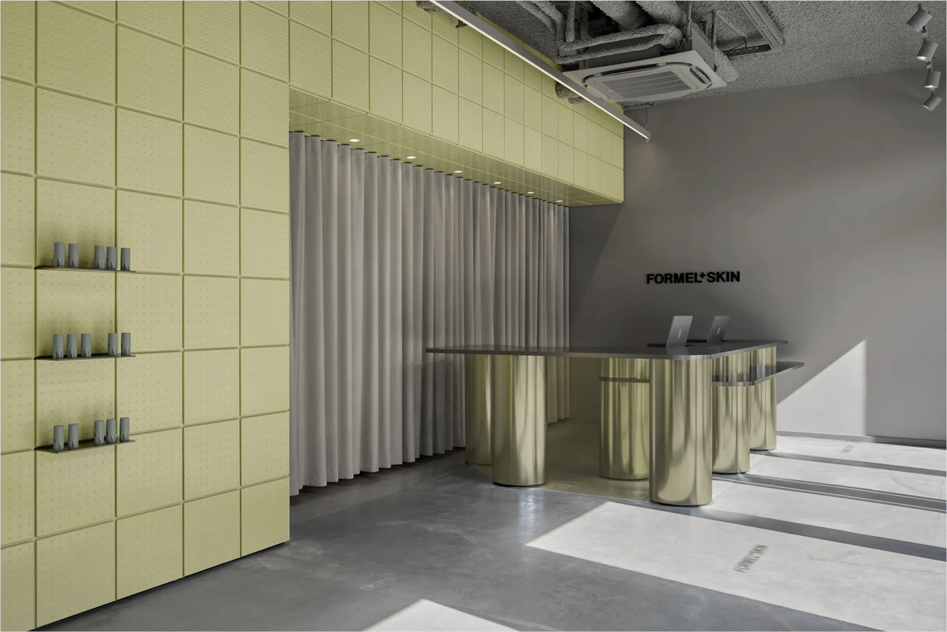 Modern retail reception area with curved brushed-metal desk, lime green padded acoustic wall panels, and grey curtain backdrop.